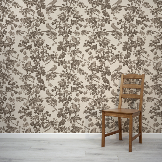 Wooden chair against a wall with floral and bird patterned wallpaper