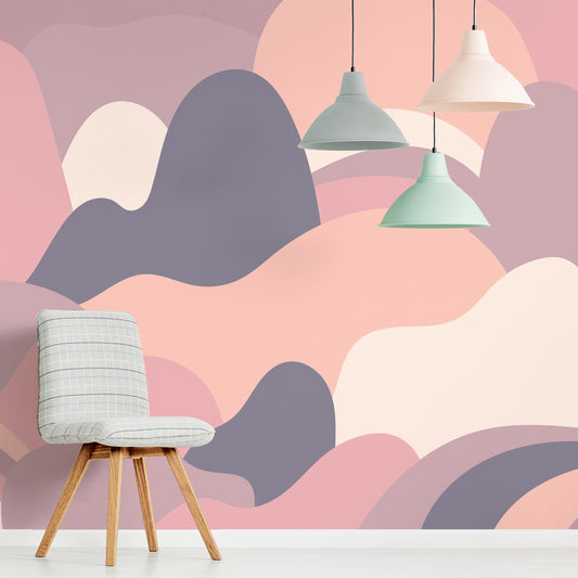 Mellow Curved Horizons wallpaper in lounge with cushioned grey chair with three hanging pastel lampshades in mint and grey and cream