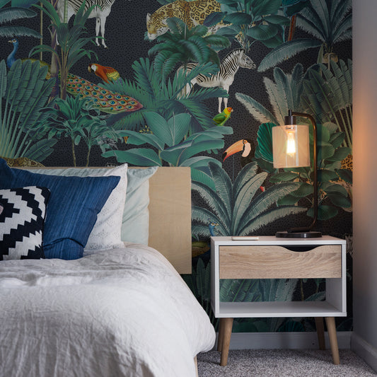 Paradise Garden Grey and Speckled Wallpaper In Dark Room With White Bed and Bedside Lamp Turned On Lighting Up Part Of The Wall