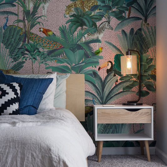 Paradise Garden Pink and Speckled Wallpaper In Dark Room With White Bed and Bedside Lamp Turned On Lighting Up Part Of The Wall