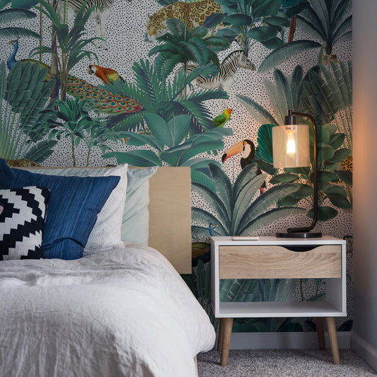 Paradise Garden White and Speckled Wallpaper In Dark Room With White Bed and Bedside Lamp Turned On Lighting Up Part Of The Wall