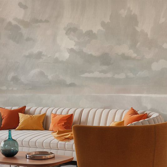 Living room with a white sofa, orange cushions, and a decorative vase against a cloud-patterned wall.