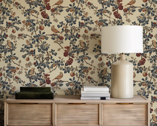 Decorative wallpaper with floral and bird pattern, wooden cabinet with lamp and books.