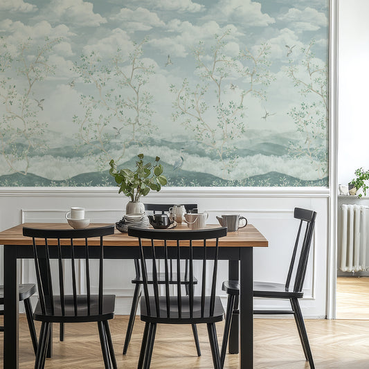 Dining room with a wooden table and black chairs against a scenic wall mural.