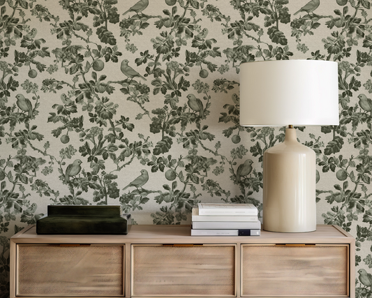 Decorative wall with floral and bird pattern, wooden console table with lamp and books.