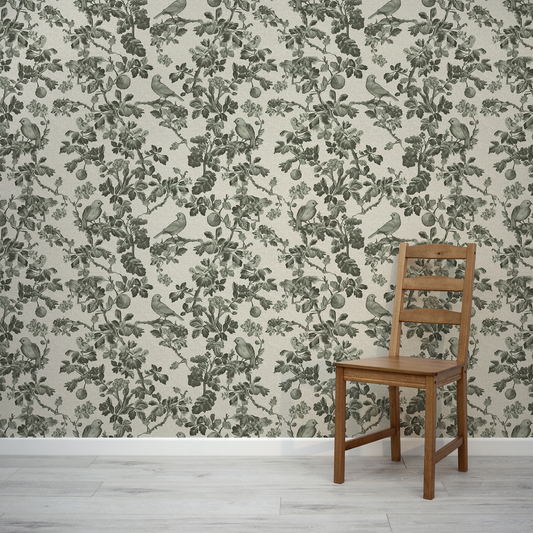 Wooden chair against a wall with floral and bird patterned wallpaper