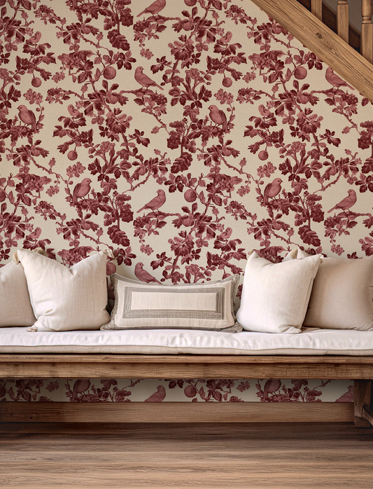 Wallpaper with red floral and bird pattern on a neutral background, with a wooden bench and cushions.